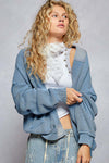 Woman wearing the Lakehouse Cardigan and blue pants.