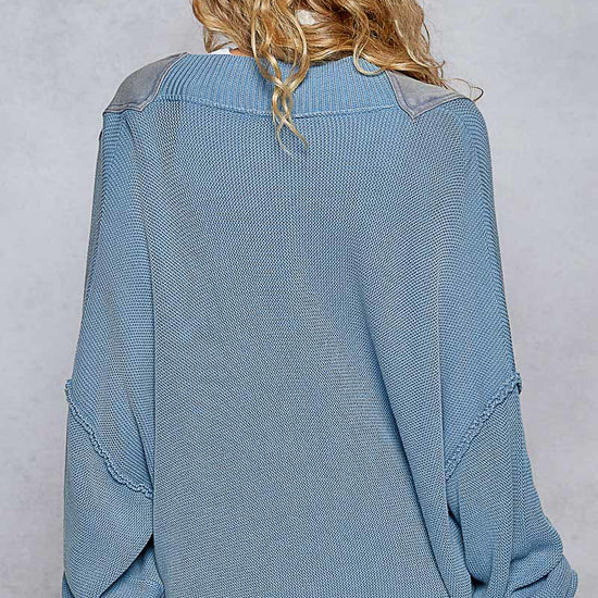A woman facing backwards wearing the Lakehouse Cardigan and blue pants.
