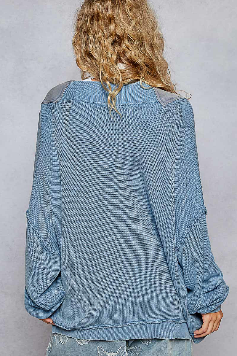 A woman facing backwards wearing the Lakehouse Cardigan and blue pants.