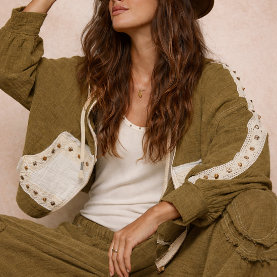 woman wearing an olive boho jacket with crochet detail and relaxed fit styled with a casual outfit on a neutral beige background, lightweight boutique jacket for everyday wear and layering