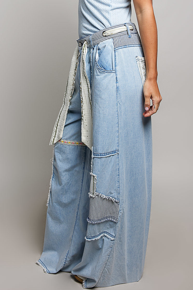 Sideview of a woman wearing Pol Clothing Wide Leg Patchwork Jeans with a grey background.