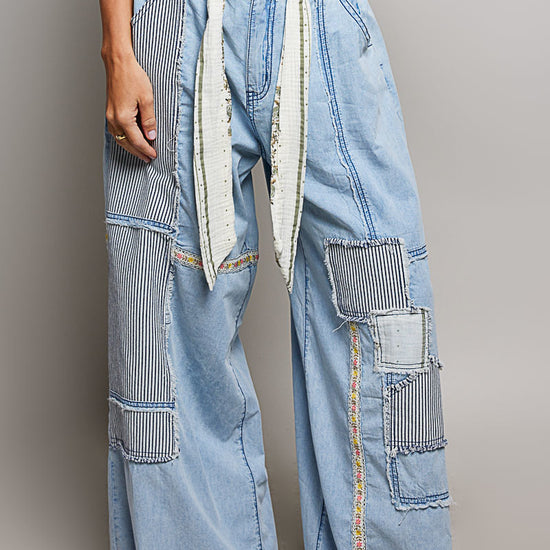 Woman wearing POL Clothing Wide Leg Patchwork jeans with a grey background.