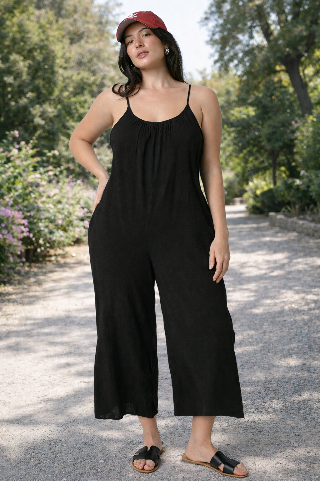 Women's black wide-leg cropped jumpsuit with spaghetti straps styled casually with sandals outdoors