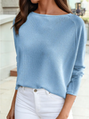 Close-up detail of a soft blue textured jacquard shift top showing fabric texture and relaxed fit styled with white jeans