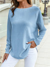 Close-up front view of a soft blue textured jacquard shift top with long sleeves, styled with white jeans for a casual everyday outfit