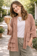 woman wearing a dusty rose BlueVelvet boho embroidered ruffle kimono top with eyelet details, styled with a white tee and sage pants, holding iced coffee outdoors