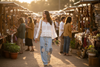 Woman walking in a market wearing the Aria Crinkle Ruffle Top and Sky breeze boho patchwork wide leg pant.