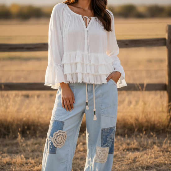 Woman wearing the Aria Crinkle Ruffle Top with Sky Breeze Patchwork Boho Wide Leg Pants, standing in a field.