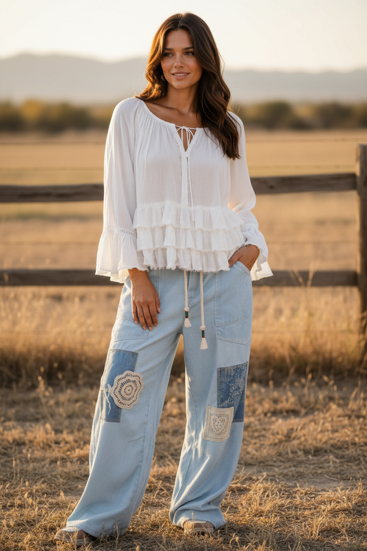 Woman wearing the Aria Crinkle Ruffle Top with Sky Breeze Patchwork Boho Wide Leg Pants, standing in a field.