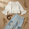 Flat lay on a neutral background of the Aria Crinkle Ruffle Top and the Sky Breeze Boho Patchwork wide leg pants
