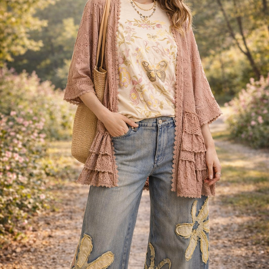 Women's boho boutique outfit featuring butterfly floral graphic tee, pink lace kimono, and floral patch wide-leg jeans