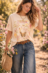 Women's boho butterfly floral graphic tee styled with denim jeans in a sunlit garden lifestyle outfit