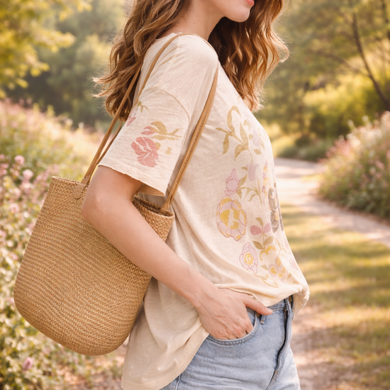Side view of women's boho butterfly floral graphic tee styled with denim shorts in a relaxed boutique summer outfit