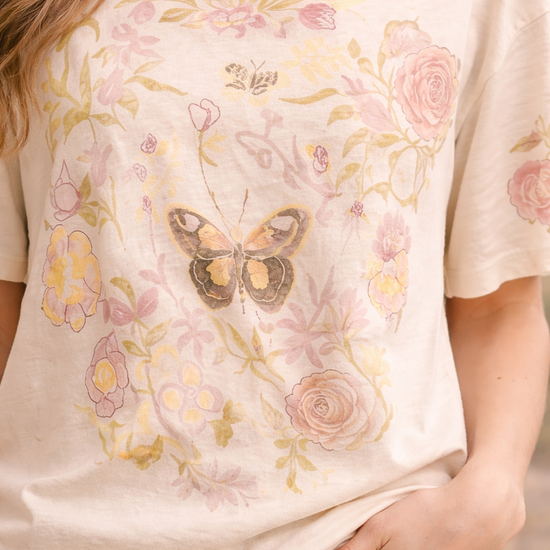 Close-up of women's butterfly floral graphic tee featuring vintage botanical butterfly design