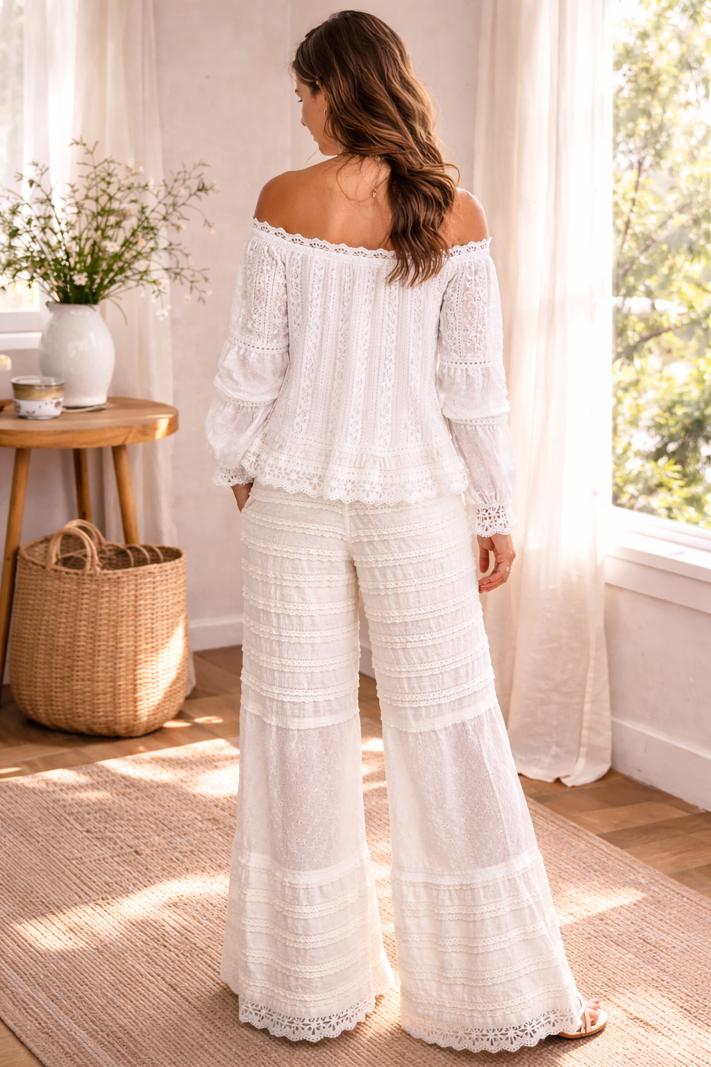 back view of woman wearing cream boho lace wide leg pants with off shoulder blouse in a soft sunlit boutique setting