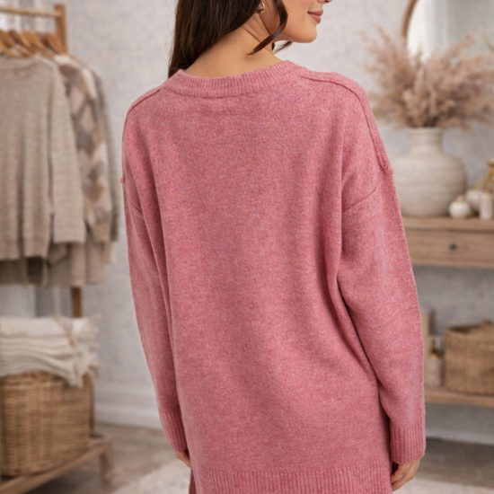 Woman facing backwards wearing a dusty rose cozy oversized knit top.