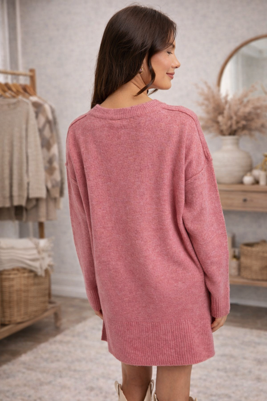 Woman facing backwards wearing a dusty rose cozy oversized knit top.