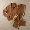 Caramel Stripe Tracksuit Set flat lay featuring matching track jacket and wide leg pants on a warm neutral linen background