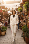 Model wearing the Ivory Crimson Stripe Tracksuit Set at an outdoor bohemian market