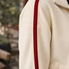 Close-up detail of ivory and crimson stripe fabric texture on the track jacket