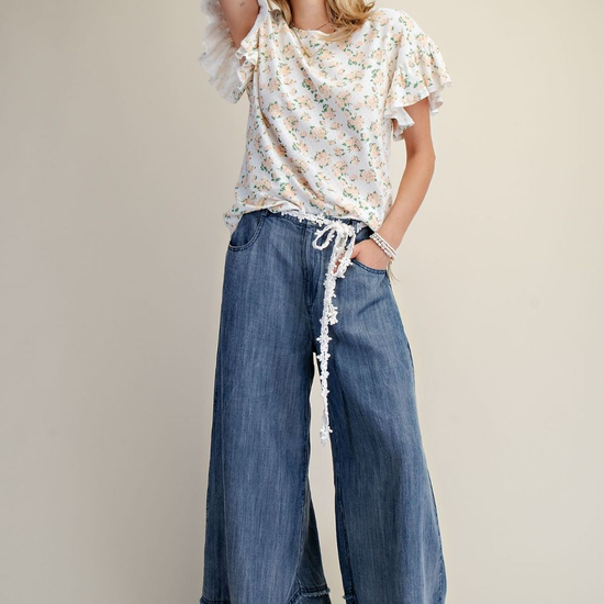 Model wearing Easel washed denim mineral washed chambray wide-leg pants with floral top and lace drawstring detail