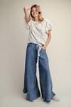 Model wearing Easel washed denim mineral washed chambray wide-leg pants with floral top and lace drawstring detail