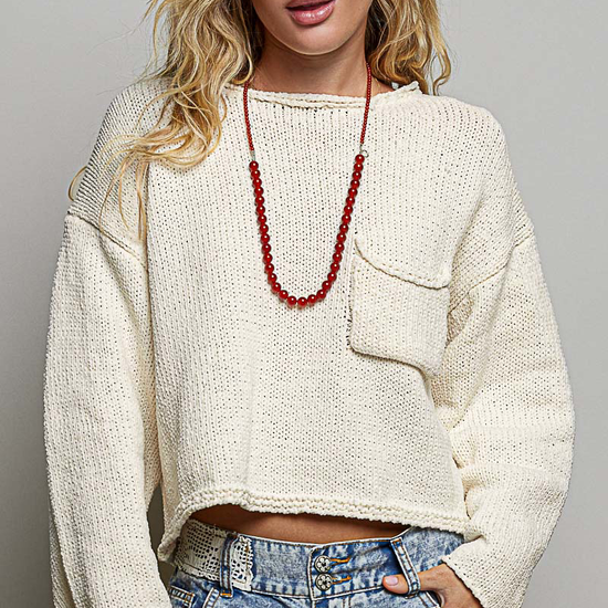 Model wearing POL Clothing cream cropped open-knit sweater with rolled neckline and chest pocket