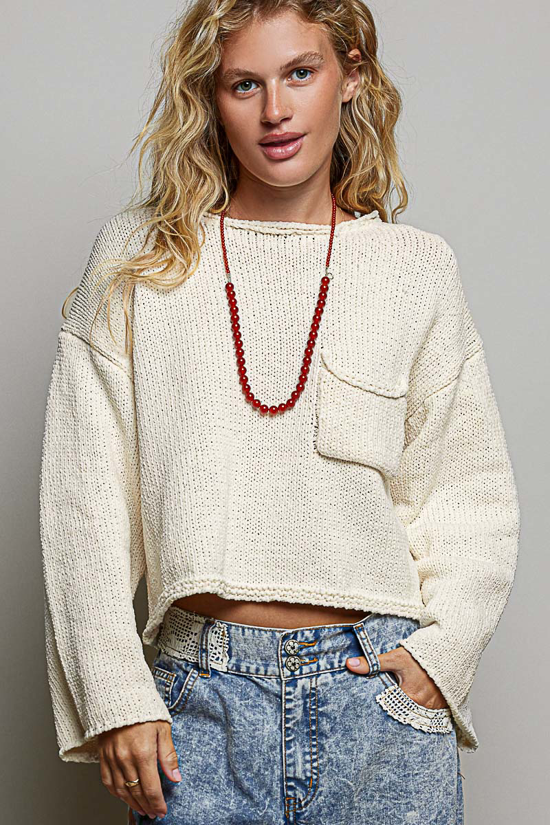 Model wearing POL Clothing cream cropped open-knit sweater with rolled neckline and chest pocket