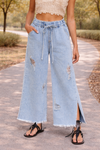 Light wash distressed wide leg jeans with paper bag waist and drawstring detail