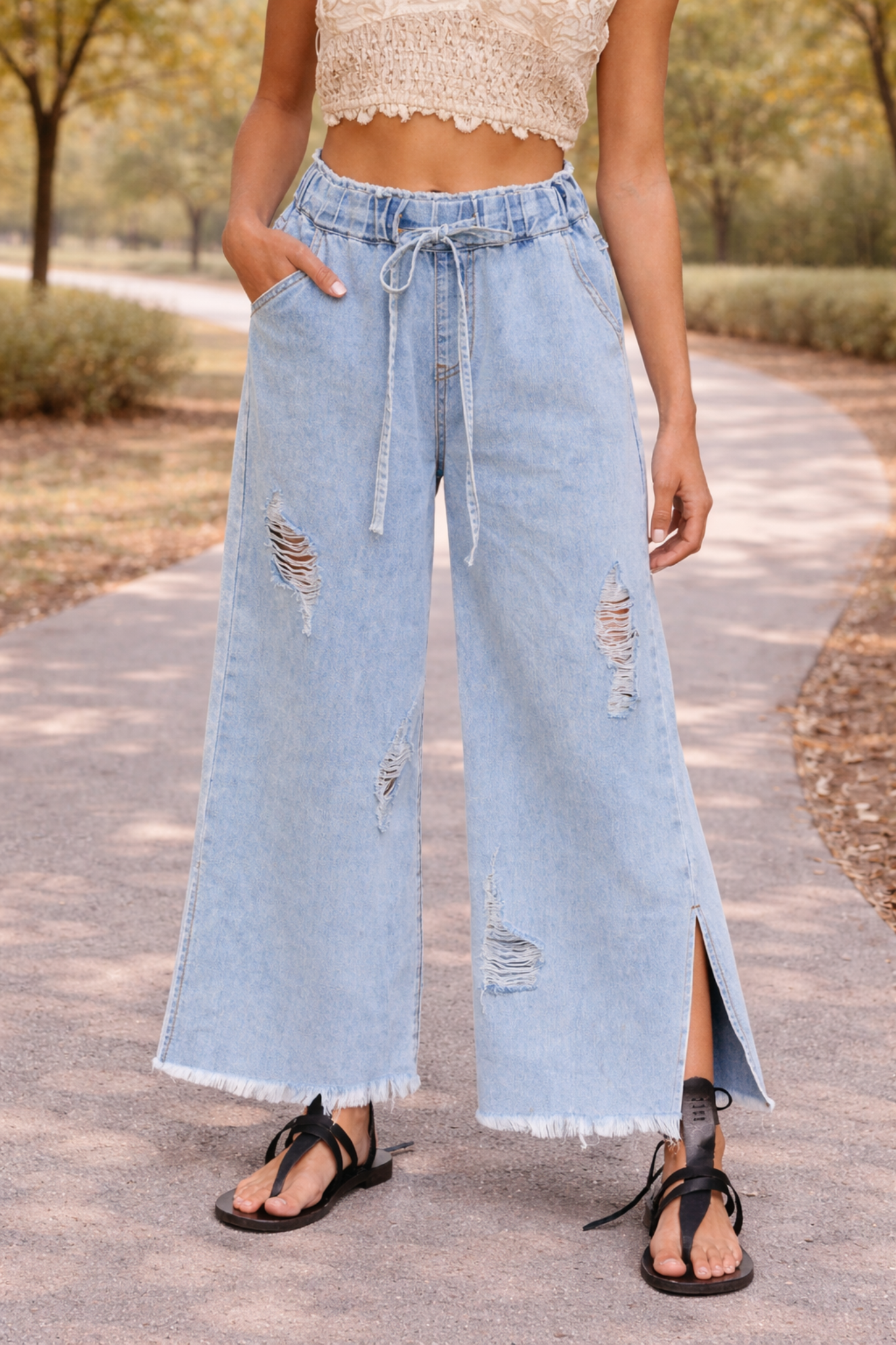 Light wash distressed wide leg jeans with paper bag waist and drawstring detail