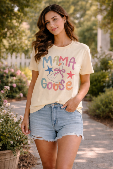woman wearing mama goose pastel graphic tee with denim shorts walking outdoors in a sunny garden setting