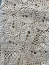 Close-up detail of natural crochet button vest showcasing intricate open-knit floral pattern and textured stitching in a soft neutral tone
