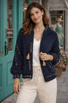 Navy boho textured cozy zip jacket with colorful stitching styled on brunette model wearing cream pants outside a boutique storefront.