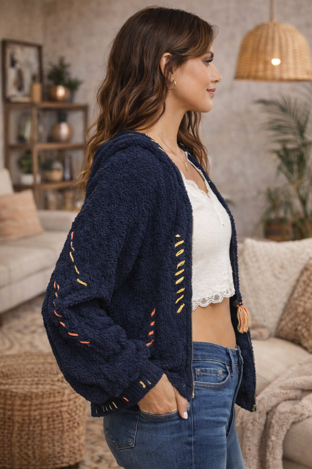 Navy boho textured cozy zip jacket with artisan stitching shown in side profile on brunette model in a warm boho boutique interior.