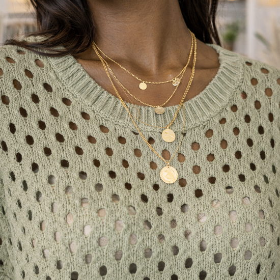Close up detail of sage green open knit sweater showing breathable crochet knit texture