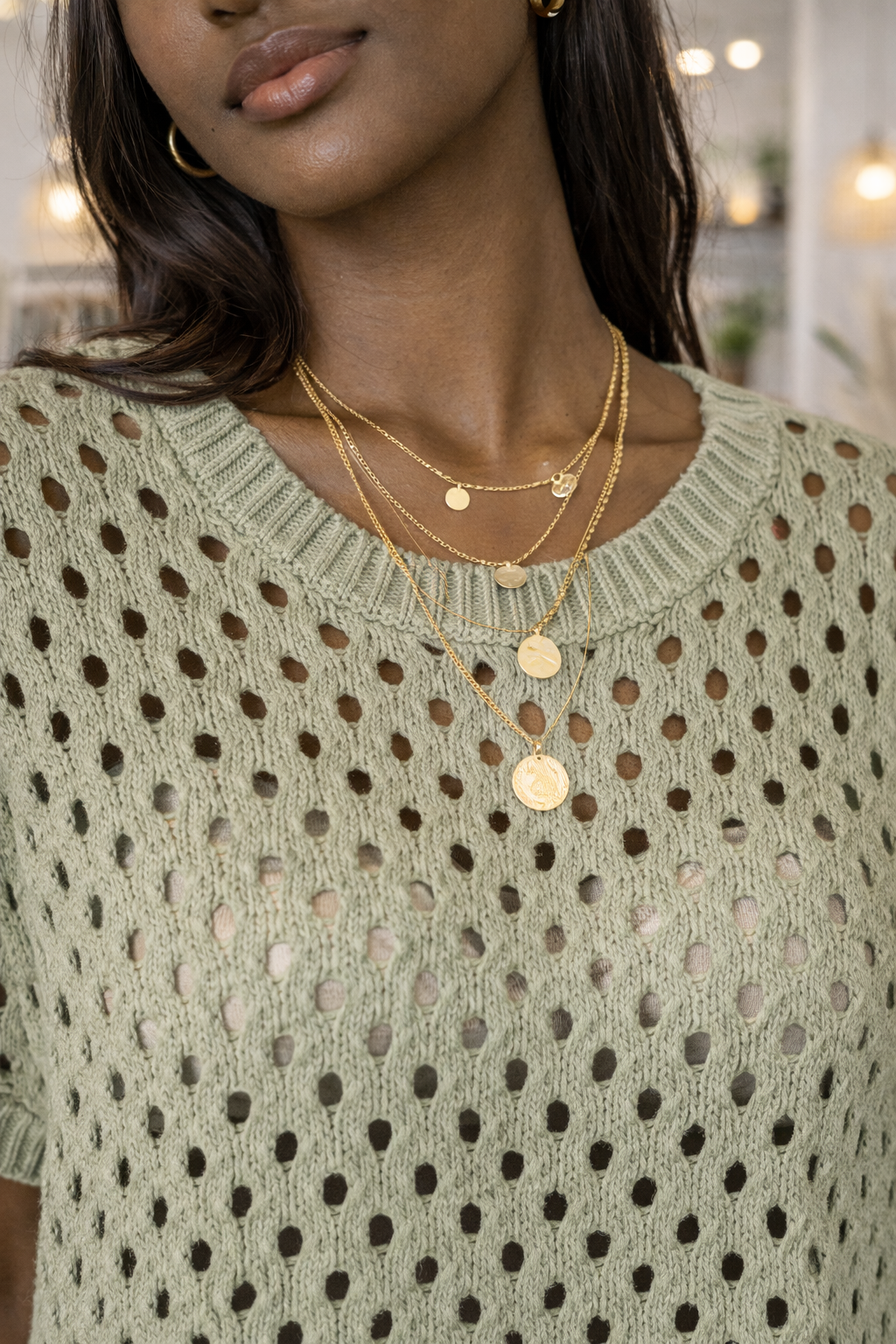 Close up detail of sage green open knit sweater showing breathable crochet knit texture