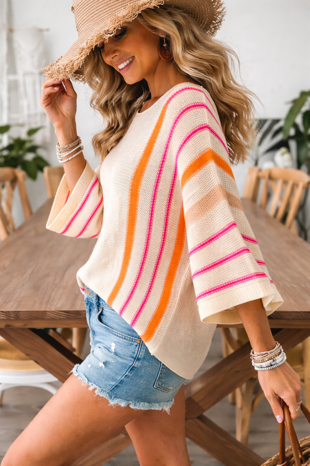 Boho lightweight knit sweater with sunset stripes in pink and orange, wide sleeve relaxed fit shown in side view for everyday casual styling