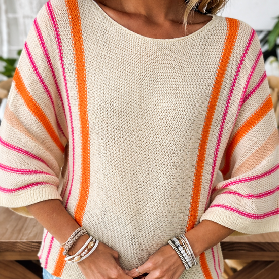 Sunset stripe wide sleeve lightweight knit sweater with pink and orange stripes, relaxed boho fit, styled with denim shorts for a casual summer outfit