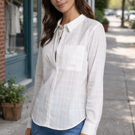 woman wearing a lightweight white button-up blouse styled in a casual outdoor street setting