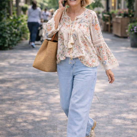 woman wearing light wash wide leg denim pants and flowy boho blouse walking outdoors